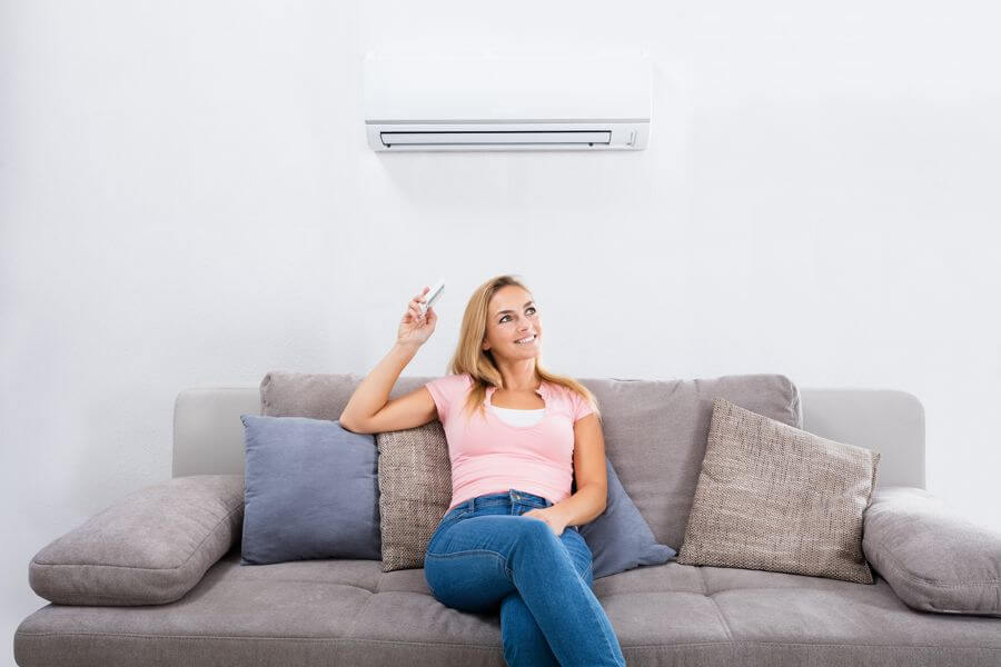 A Stanhope homeowner adjusting the temperature on her ductless unit